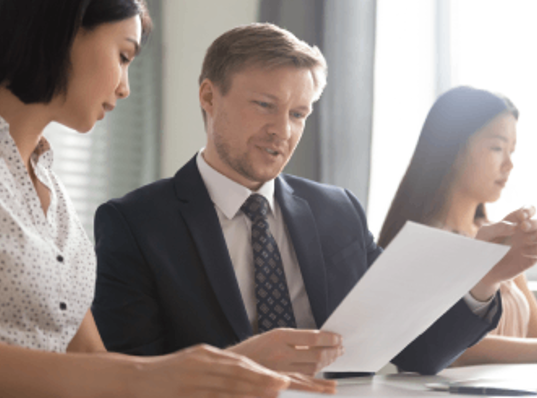 Three People Looking At Document