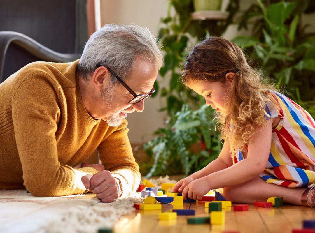 Grandfather And Grandchild Playing With Lego