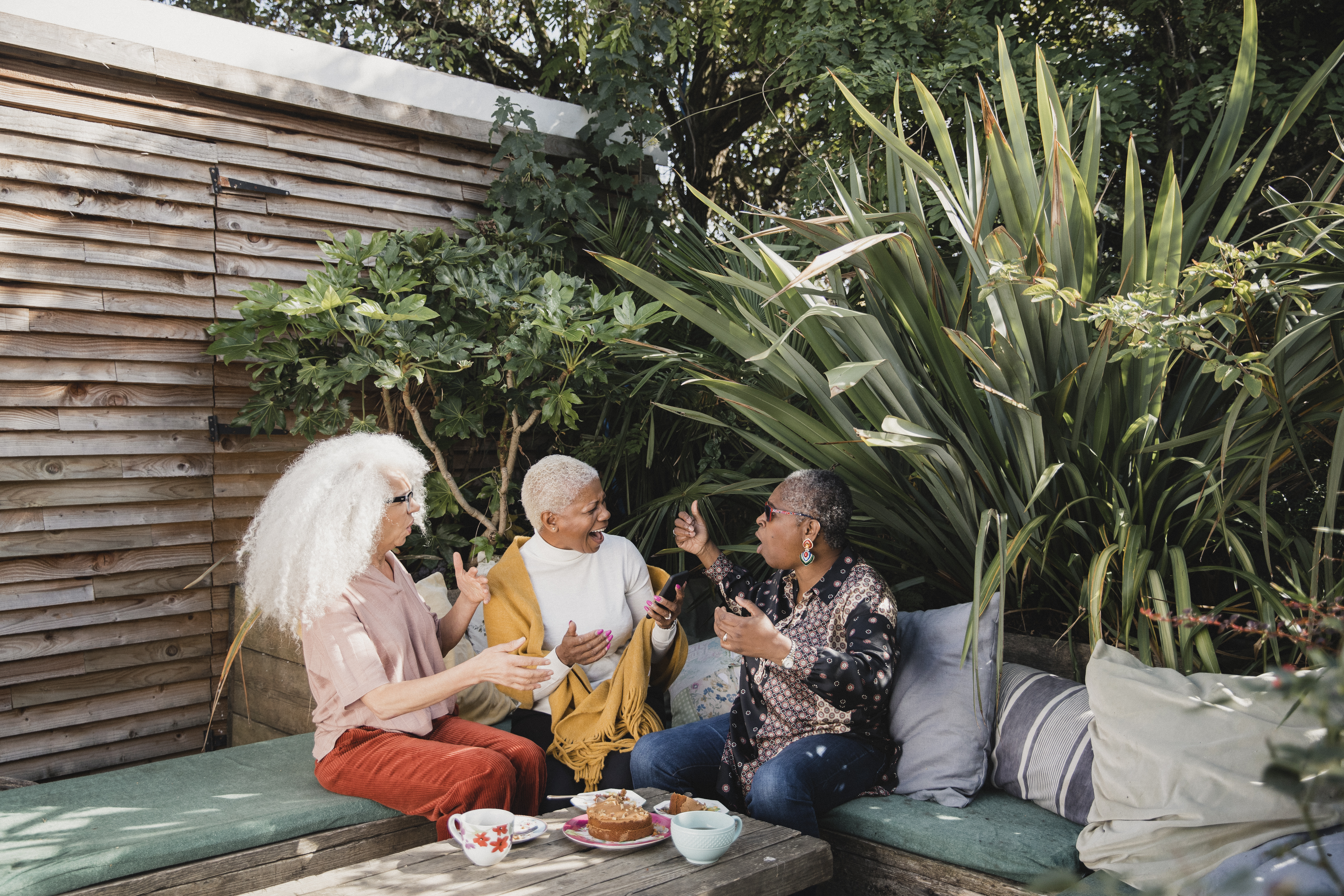 Three People Talking In A Garden