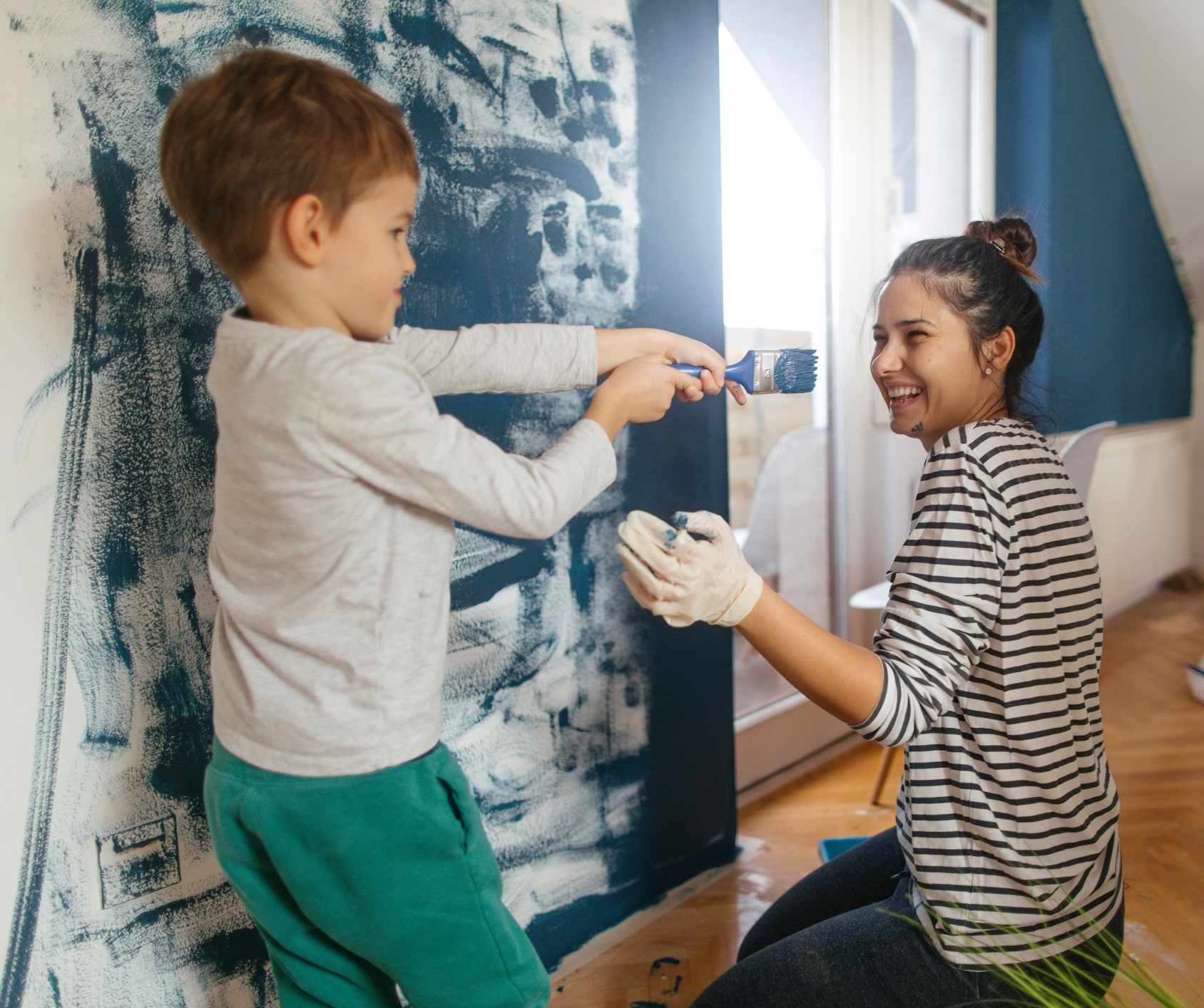 Mother And Son Decorating A Room