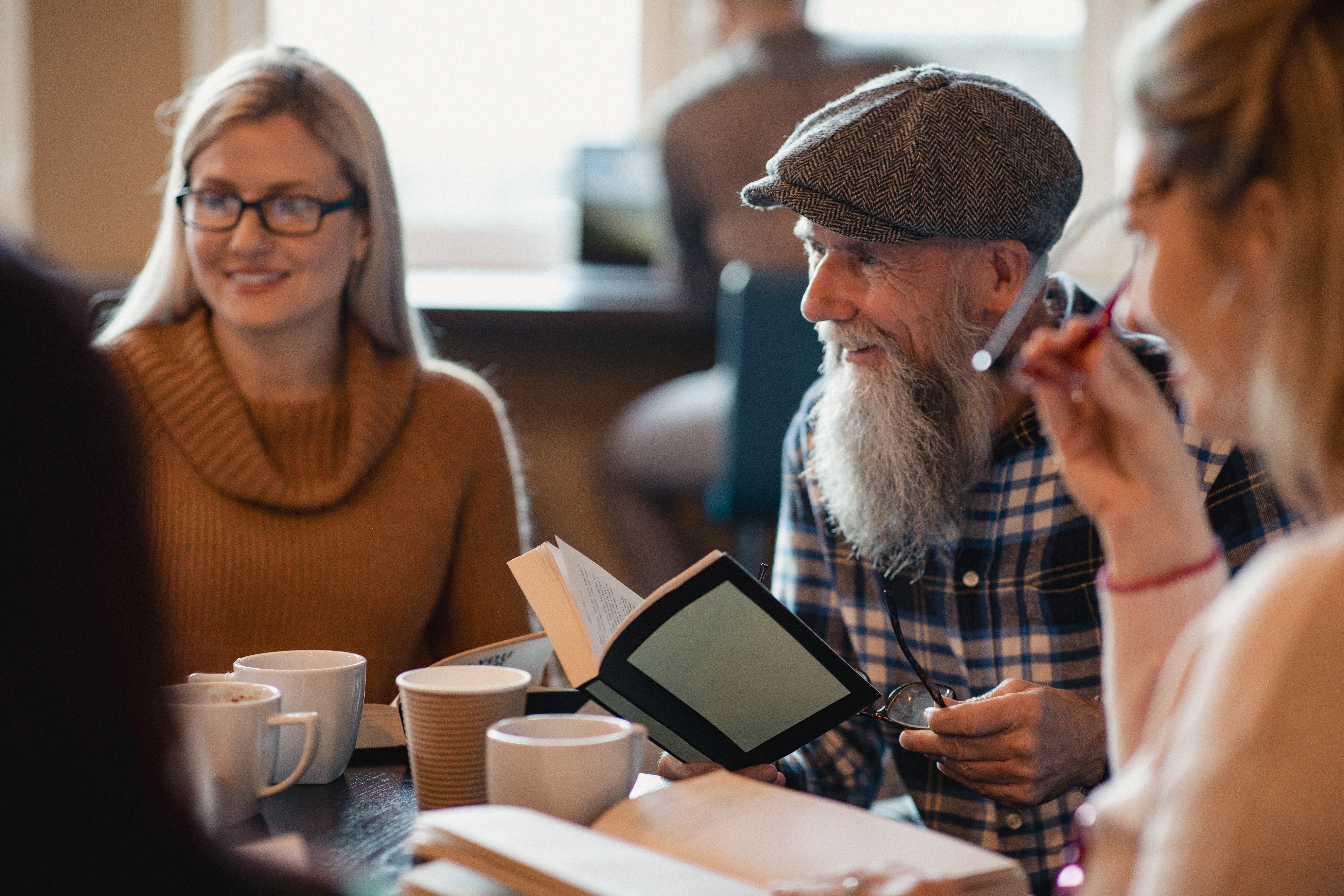 Group Reading Together In A Cafe