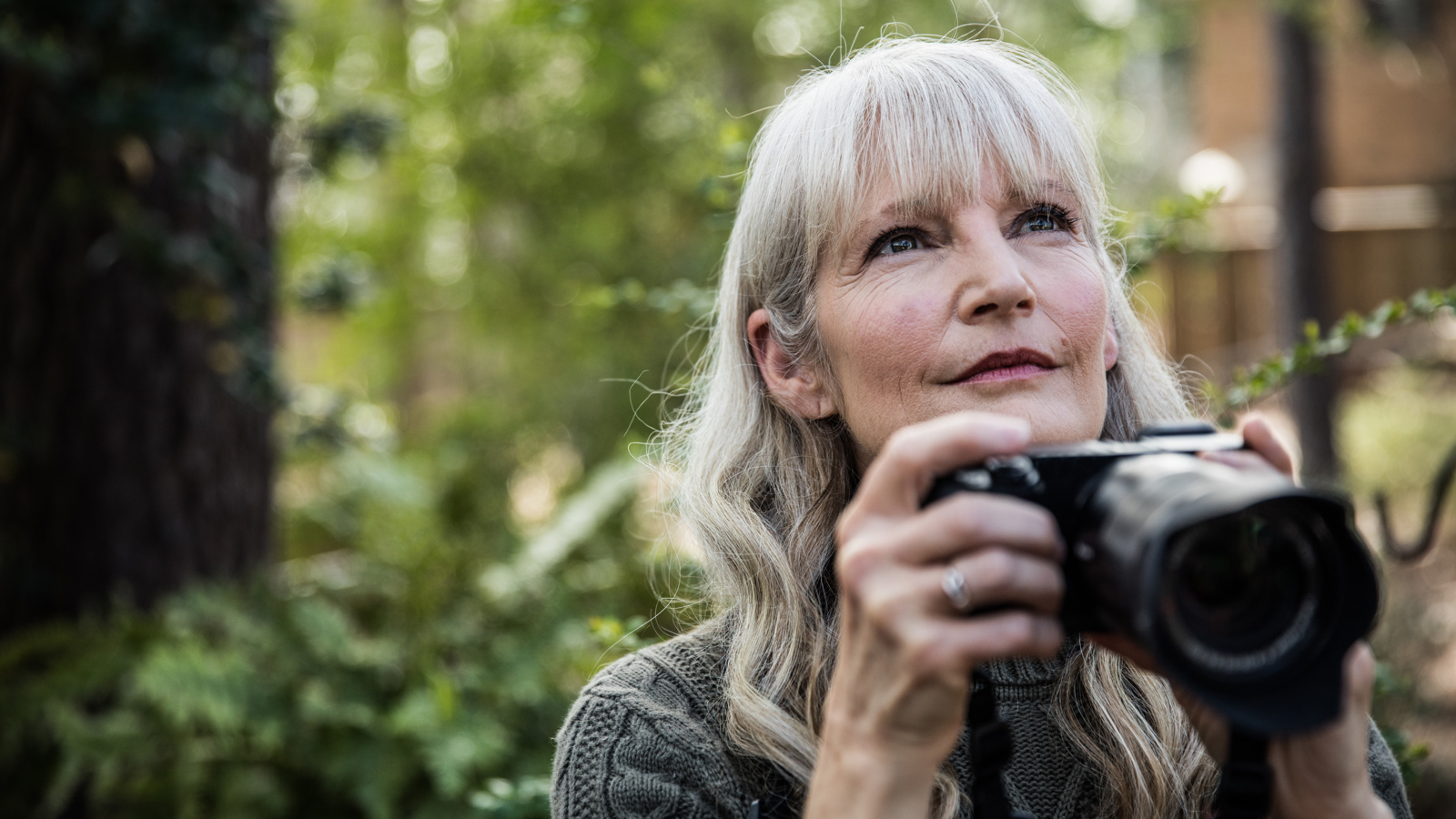 Woman Holding A Camera In The Forest